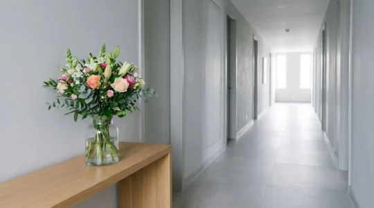 Fresh flower arrangement in cool hallway environment with soft indirect natural light and stable temperature